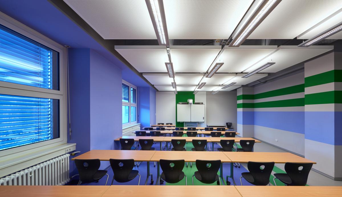 Deckensegel im Schulungsraum mit blau-grau-grün gestreiften Wänden